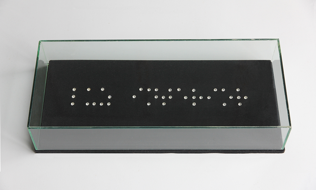 frase en Braille con cristales de cuarzo : “Luz interior”. Terciopelo, vidrio, 42x18x9cm.